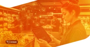 Operadora em supermercado moderno analisa estoque em tablet integrado ao e-commerce, ilustrando ruptura de estoque e-commerce supermercado.